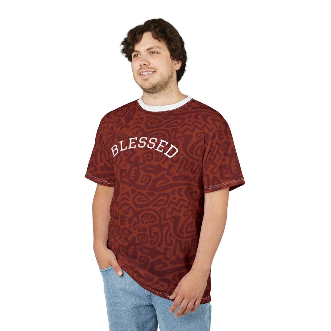 Man wearing a brown Blessed T-Shirt with abstract patterns and jeans