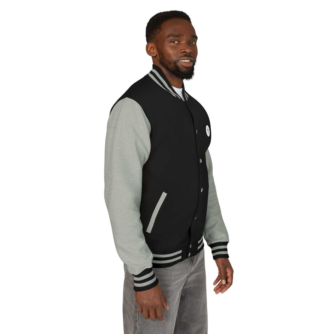 Man wearing Christian Cross jacket with black body and gray sleeves, featuring a bold cross design and striped cuffs.