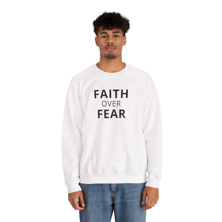 White Faith Over Fear sweatshirt with bold black text worn by male model