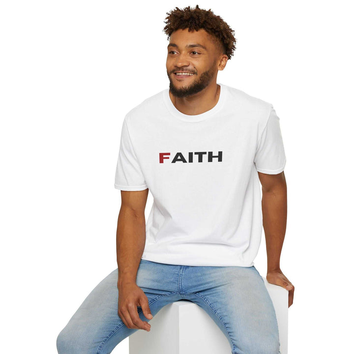 Man wearing white Faith T-Shirt with bold lettering, paired with light blue jeans, sitting and smiling