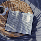Open book with Love Pattern Bookmark on wooden table next to coffee