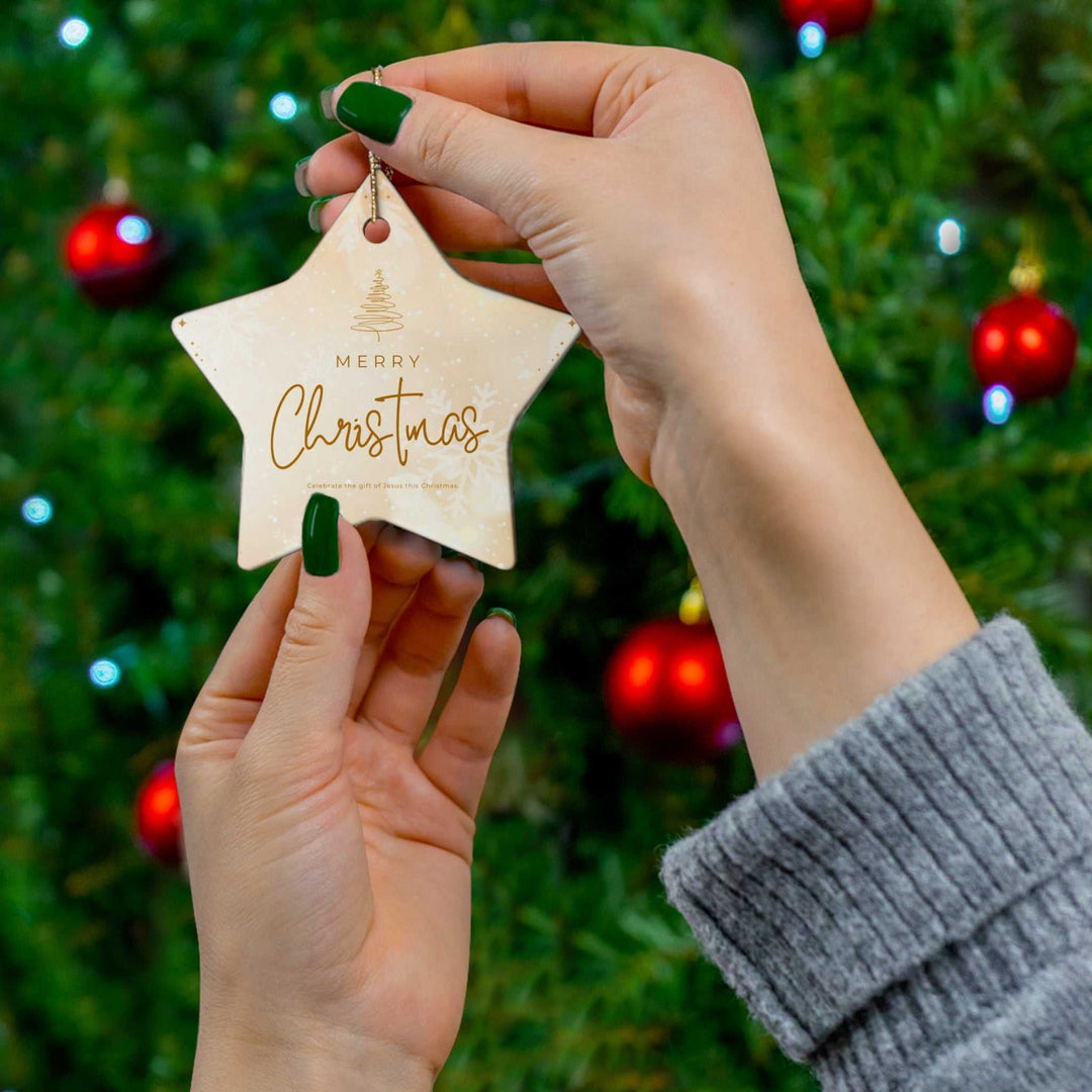 Ornament with Merry Christmas text in front of decorated Christmas tree