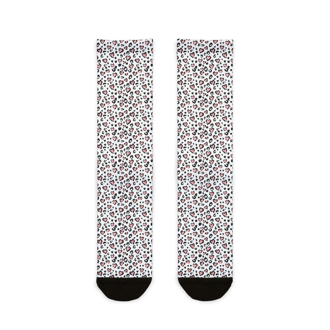 Pair of white crew socks with leopard print hearts pattern