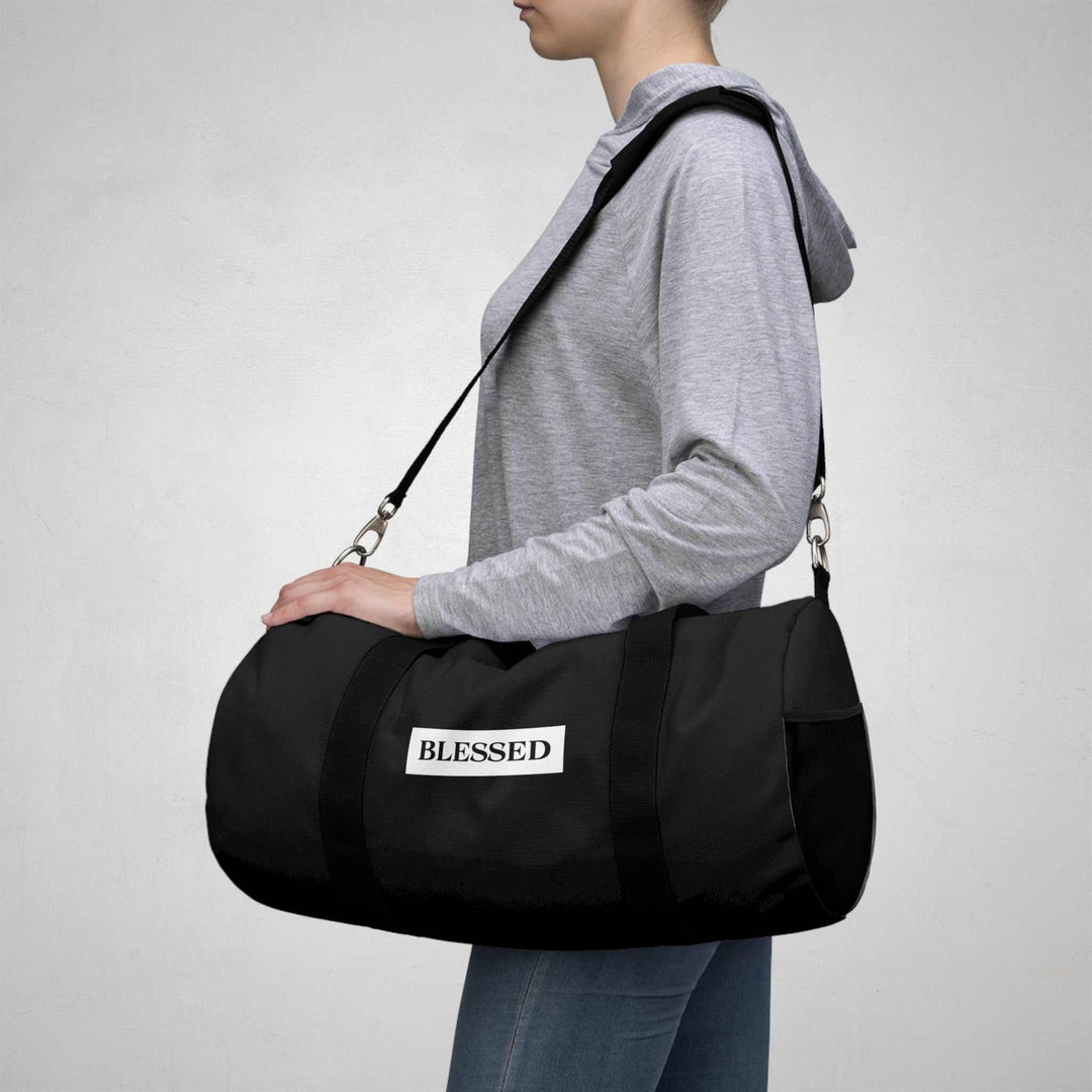 Person carrying black Blessed Duffel Bag with adjustable shoulder strap