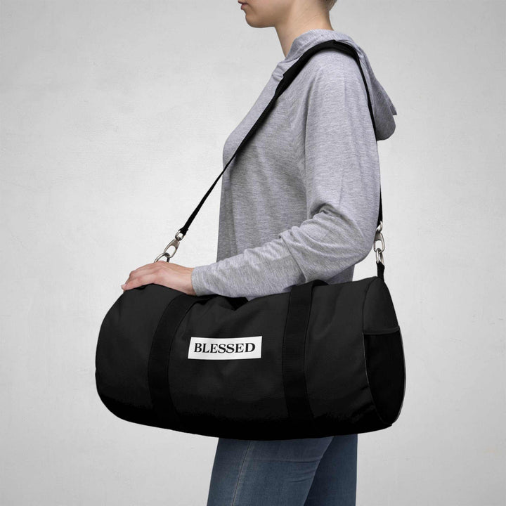 Person carrying black Blessed Duffel Bag with adjustable shoulder strap