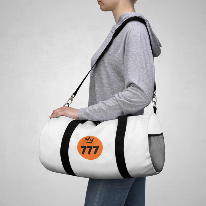 Person carrying white 777 Duffel Bag with black straps over shoulder