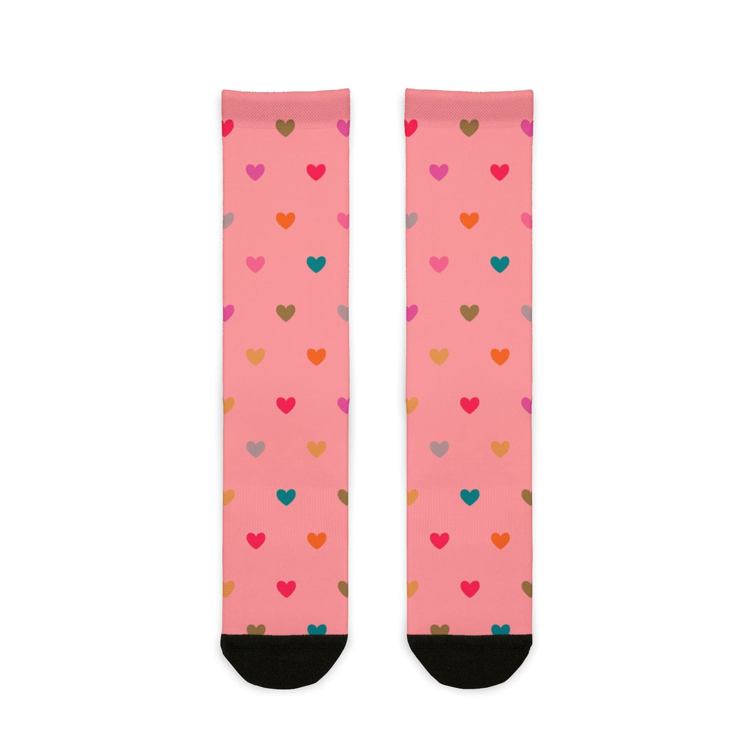 Pink crew socks with multicolored heart patterns and black heel