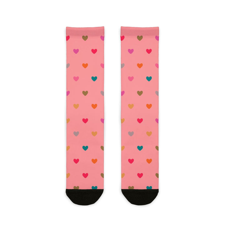 Pink crew socks with multicolored heart patterns and black heel