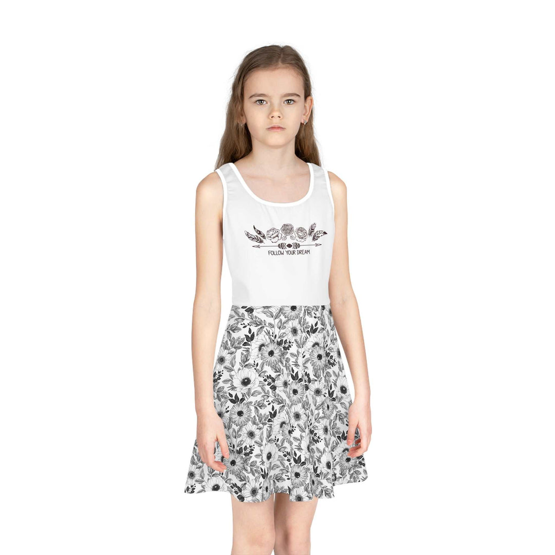 Girl wearing a white sleeveless sundress with floral print skirt and "Follow Your Dream" text on the bodice