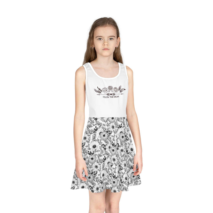 Girl wearing a white sleeveless sundress with floral print skirt and "Follow Your Dream" text on the bodice