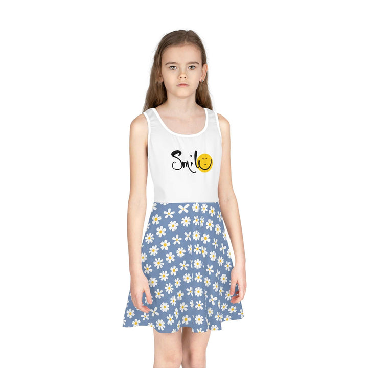 Girl wearing a sleeveless sundress with a white top featuring "Smile" text and a smiley face, paired with a blue daisy-patterned A-line skirt.