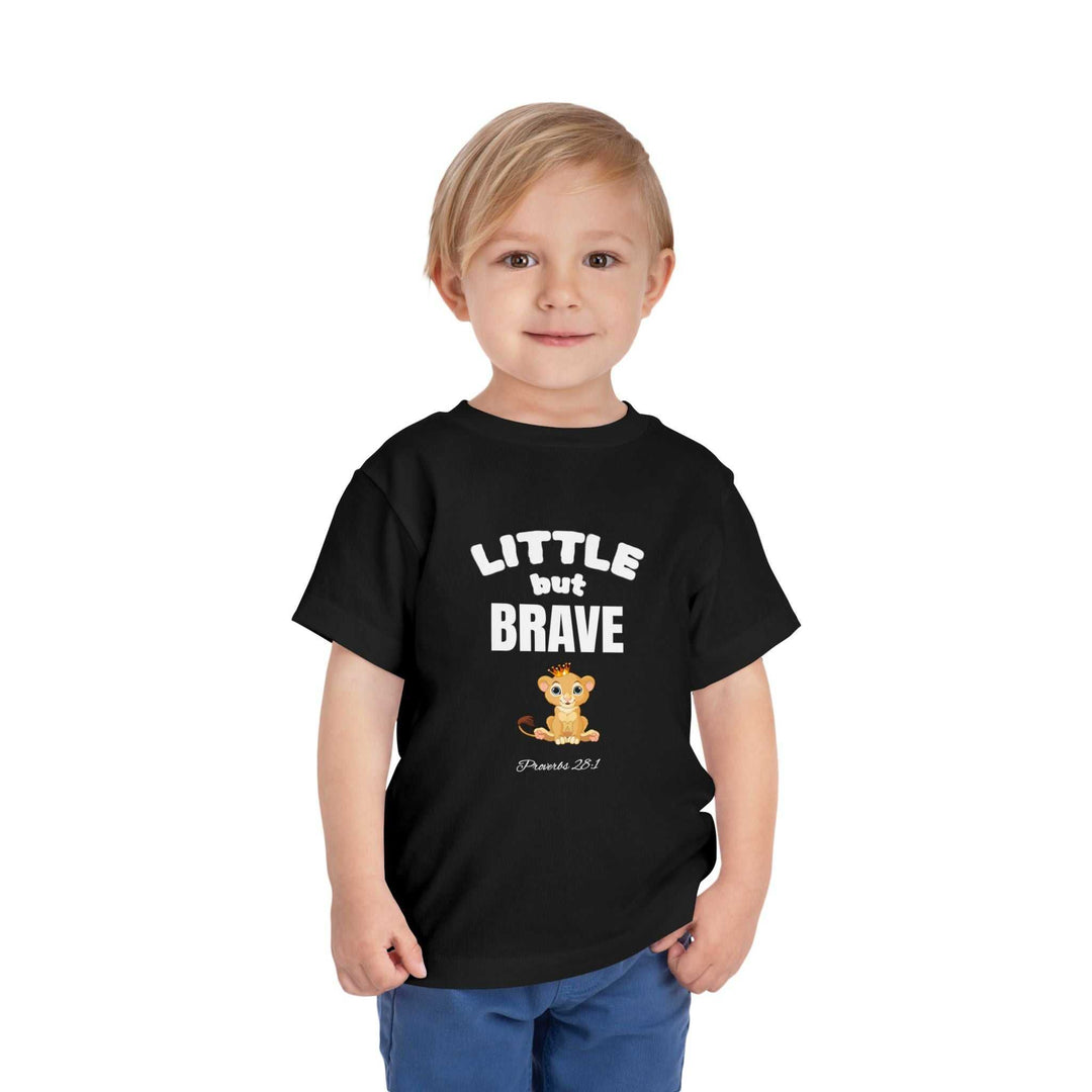 Toddler wearing black Little but Brave T-shirt with lion graphic and text, soft cotton fabric.
