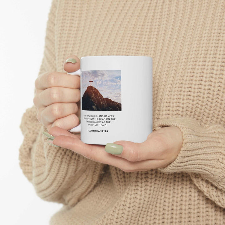 White ceramic Hope Alive mug with uplifting scripture and cross image, held in hands against beige sweater background