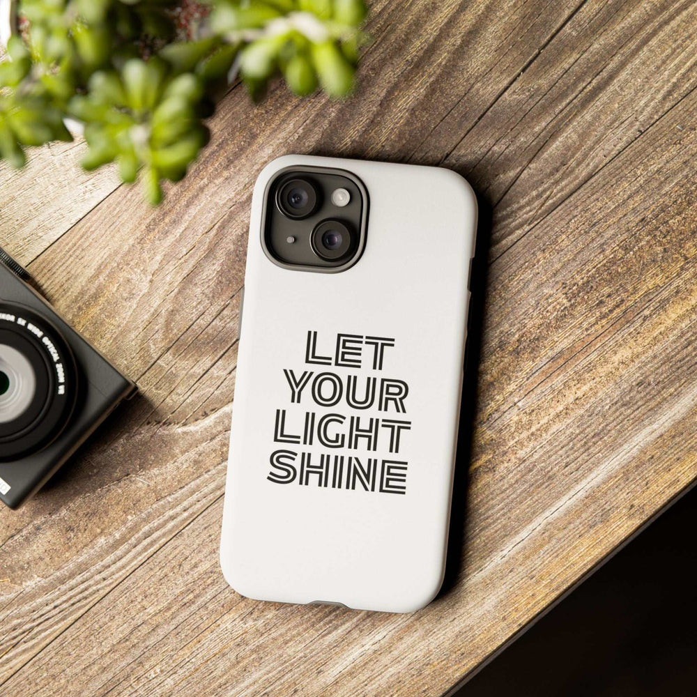 White matte phone case with "Let Your Light Shine" text, durable dual-layer design for protection and wireless charging compatible.