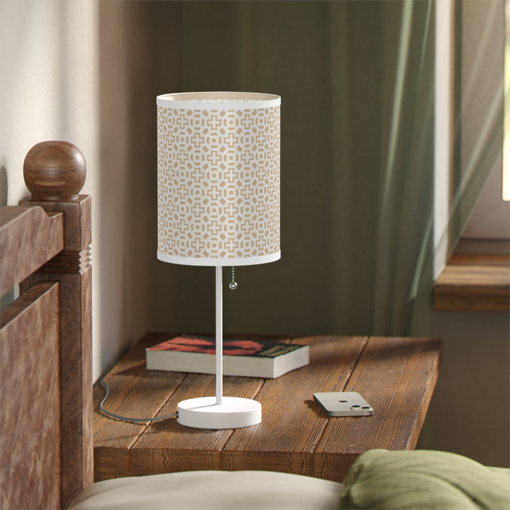 White cross design lamp with steel base on wooden bedside table