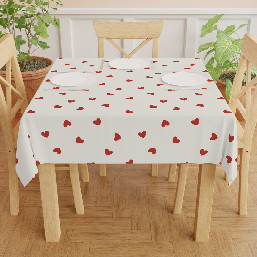 White hearts pattern tablecloth on wooden dining table with chairs