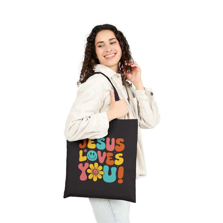 Woman carrying God’s Love Tote Bag with "Jesus Loves You" design