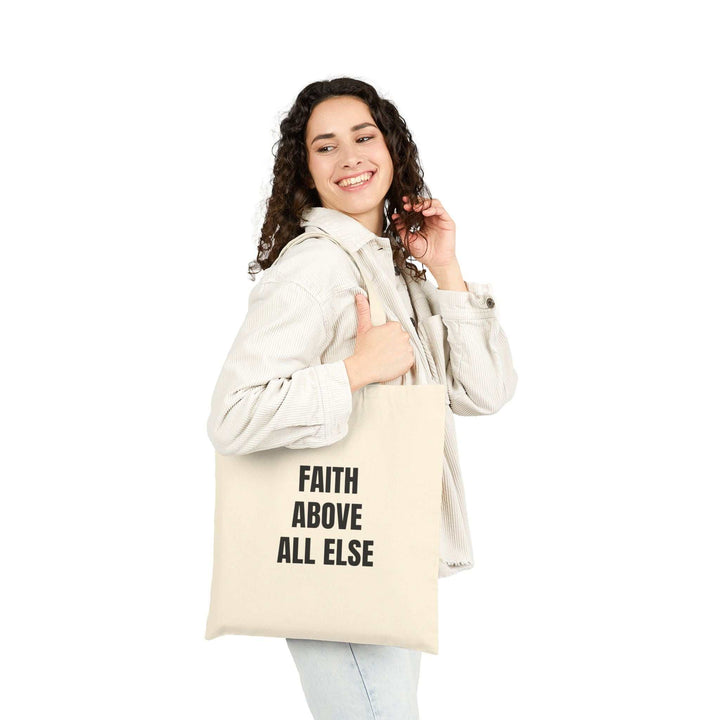 Woman carrying Tote Bag with "Faith Above All Else" text