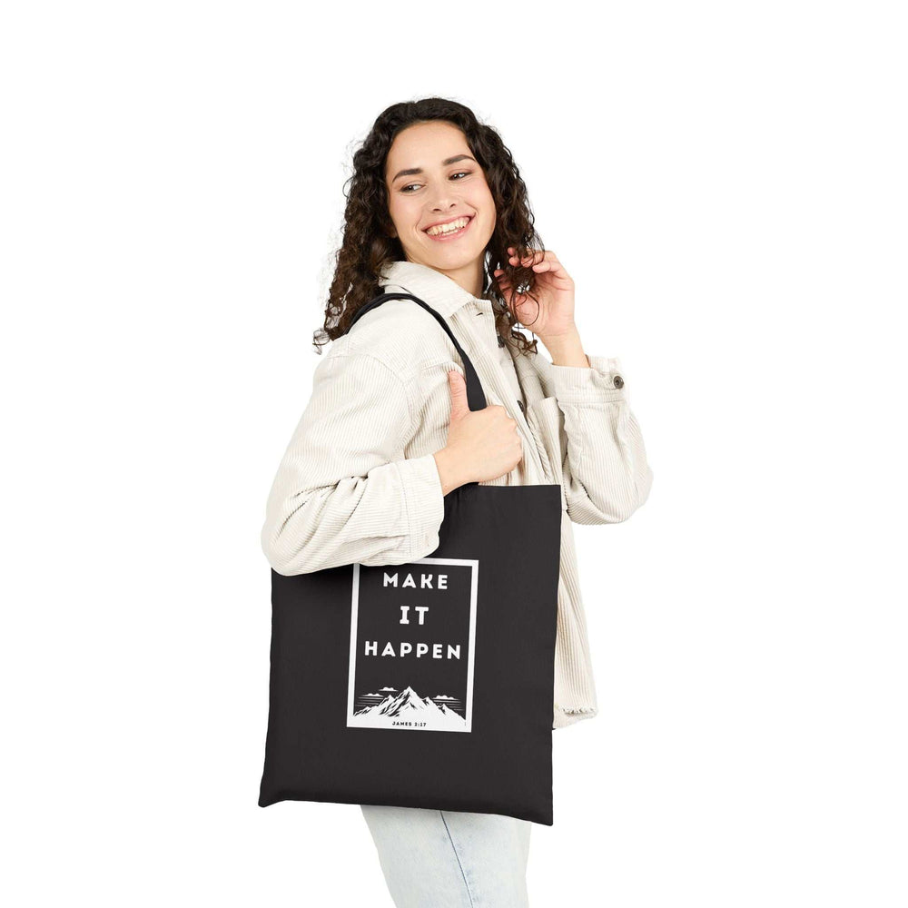 Woman carrying black "Make It Happen" cotton canvas tote bag with motivational design