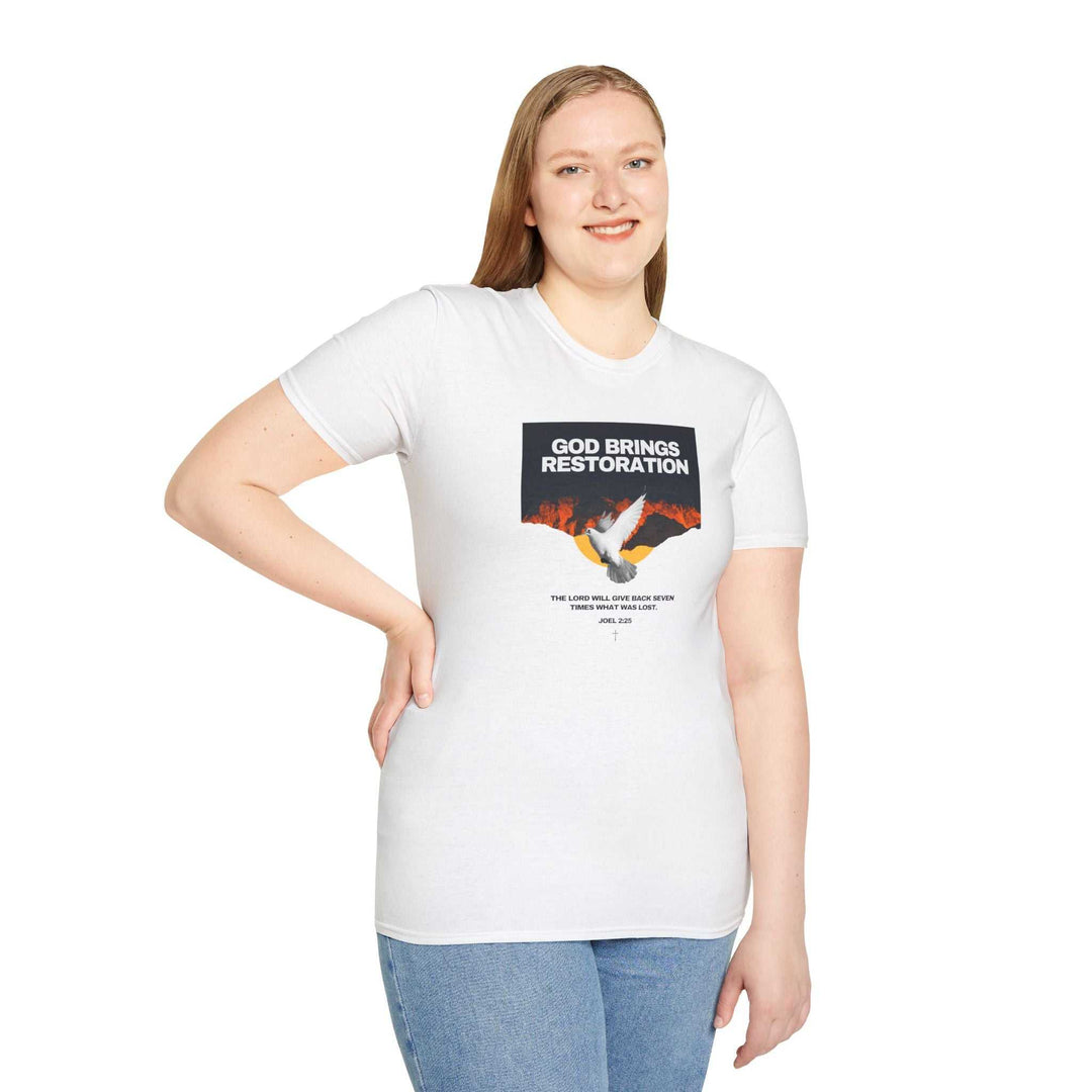 Woman wearing a white Restored by Grace T-Shirt with "God Brings Restoration" text and a dove graphic, paired with blue jeans.
