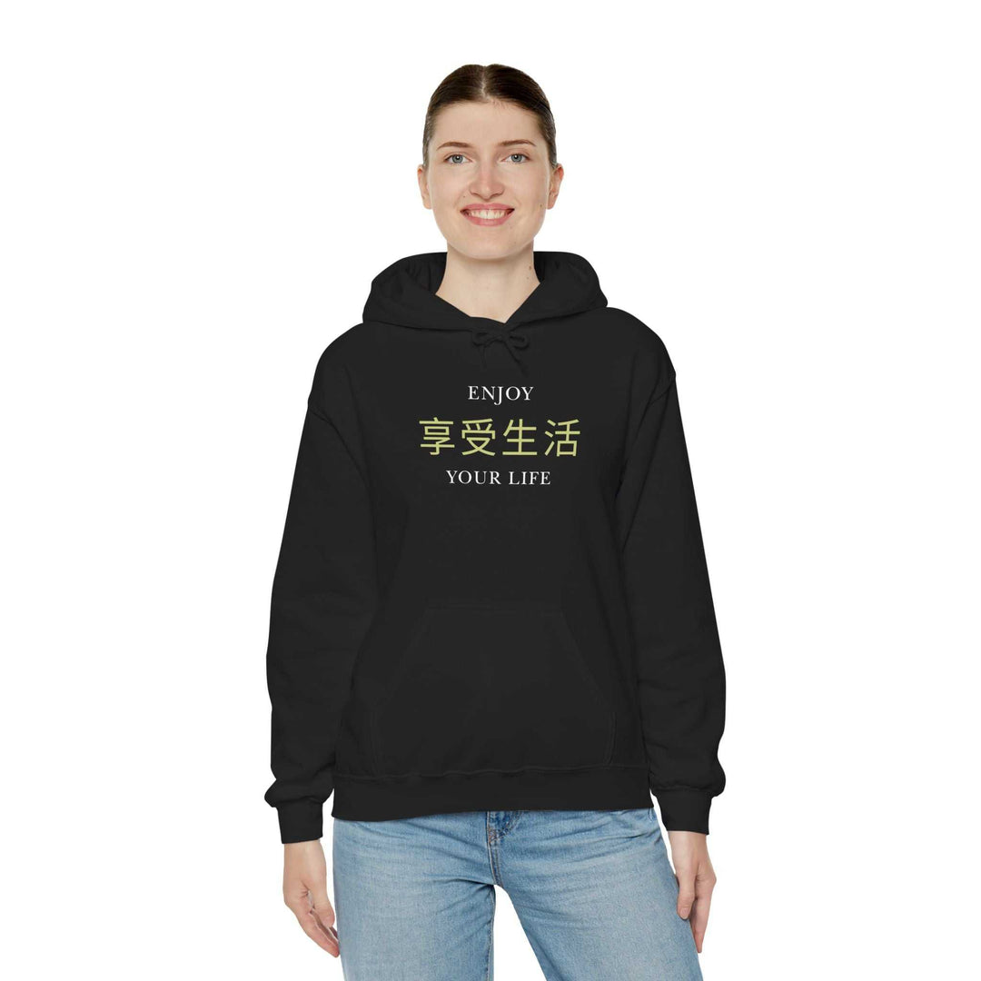 Black Enjoy Your Life hoodie with inspiring text in English and Chinese, worn by a smiling person in blue jeans, classic fit and cozy style