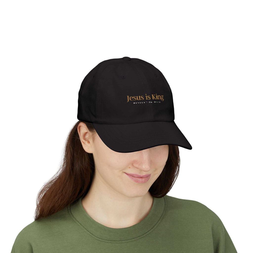 Woman wearing black Jesus is King Cap with gold embroidery