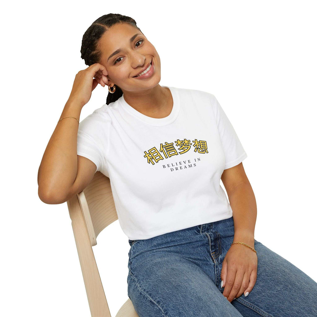 Woman wearing white Believe In Dreams t-shirt with inspirational text and blue jeans sitting on wooden chair