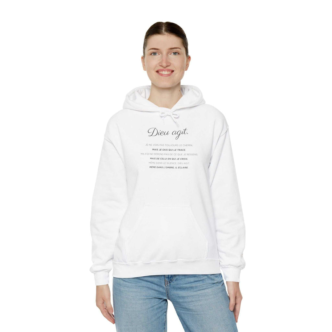 Woman wearing a white Dieu En Action hoodie with faith-inspired text, styled with blue jeans