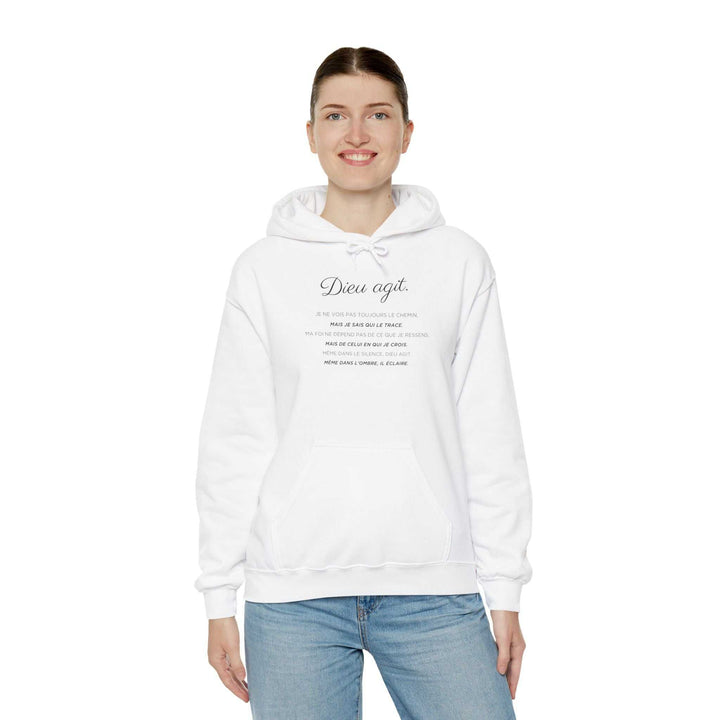 Woman wearing a white Dieu En Action hoodie with faith-inspired text, styled with blue jeans