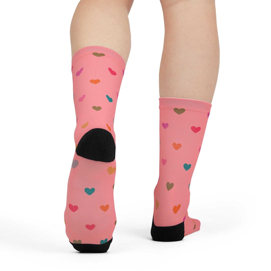 pink crew socks with multicolor hearts pattern and toe accents