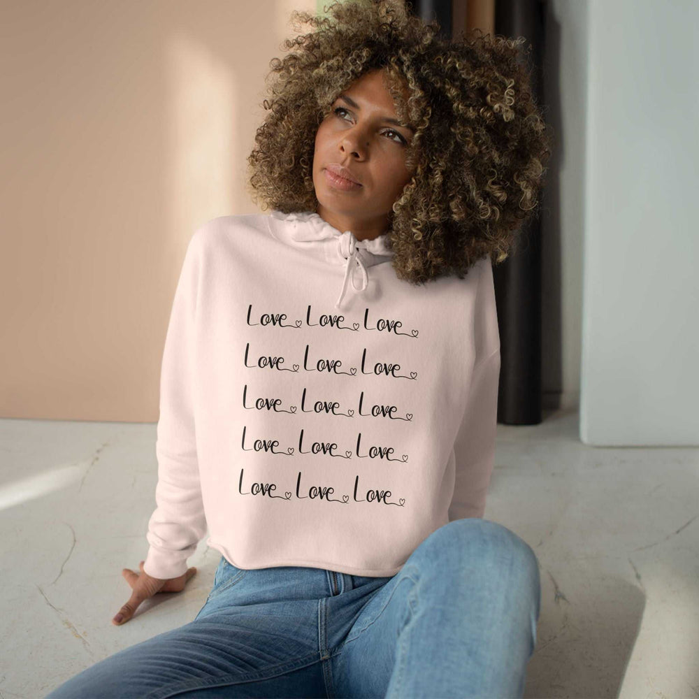 woman wearing pink Love Crop Hoodie with repeated love text